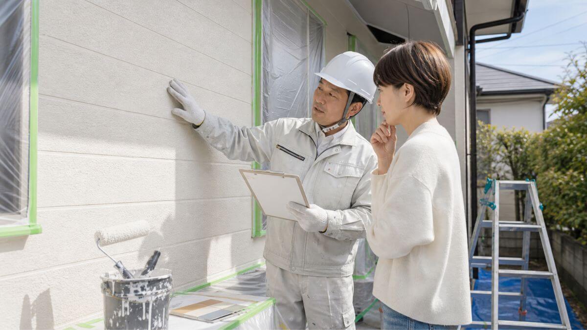 塗装業者と外壁を確認する様子